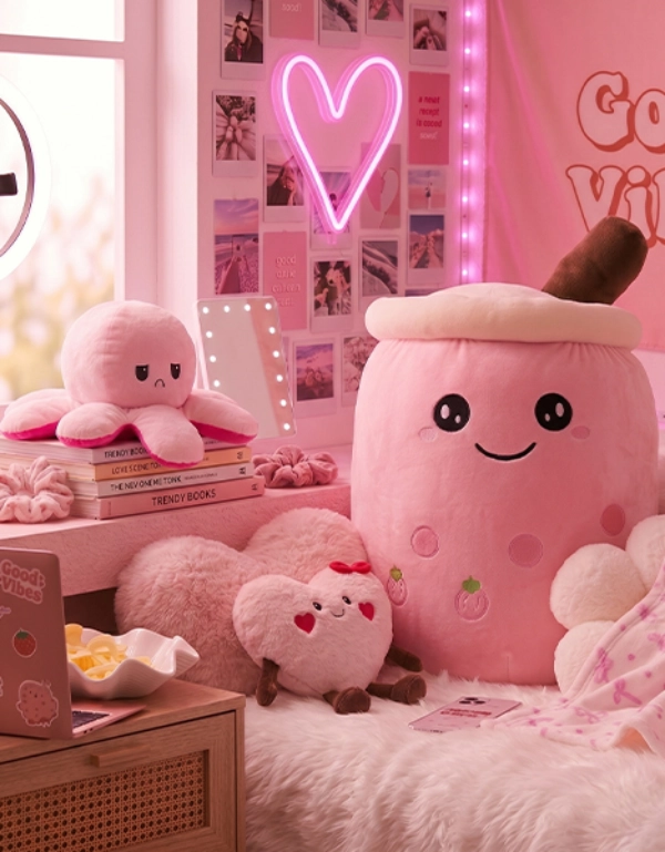 Gemütlich eingerichtetes Zimmer mit rosa Plüschtieren, Herzleuchte, Laptop und Dekoration im Social-Media-Stil – trendige Wohnaccessoires und Kuschelartikel