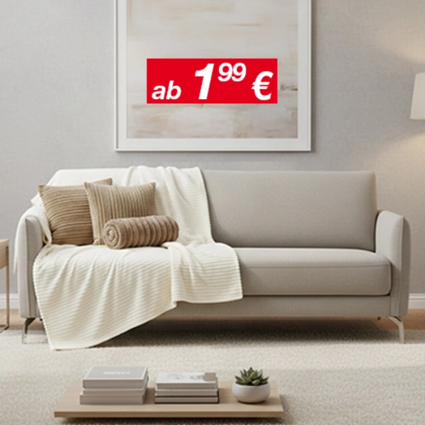 Wohlfühlmomente zum Sparpreis Helles Wohnzimmer mit grauem Sofa, Kissen und Decke, Beistelltisch und Stehlampe.