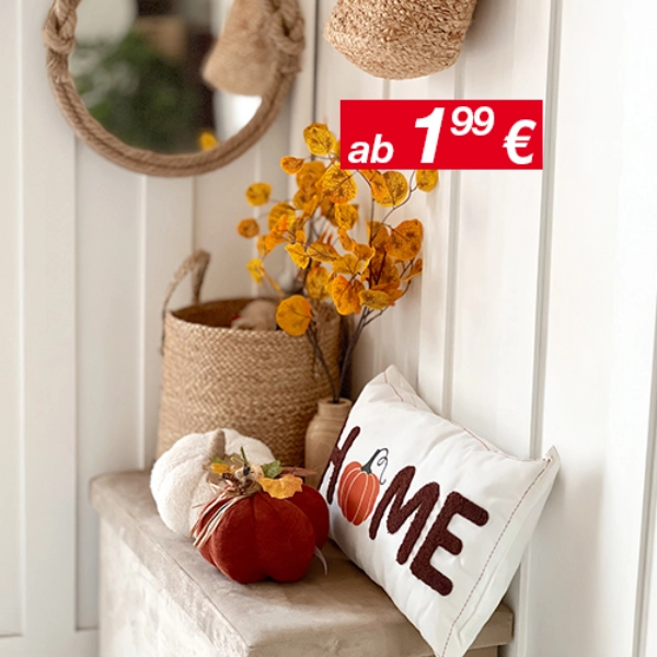 Gemütliche Wohnkultur mit einem runden Spiegel, geflochtenen Körben, Herbstblättern und einem dekorativen Kissen mit der Aufschrift „HOME“ und einem Kürbis-Akzent.