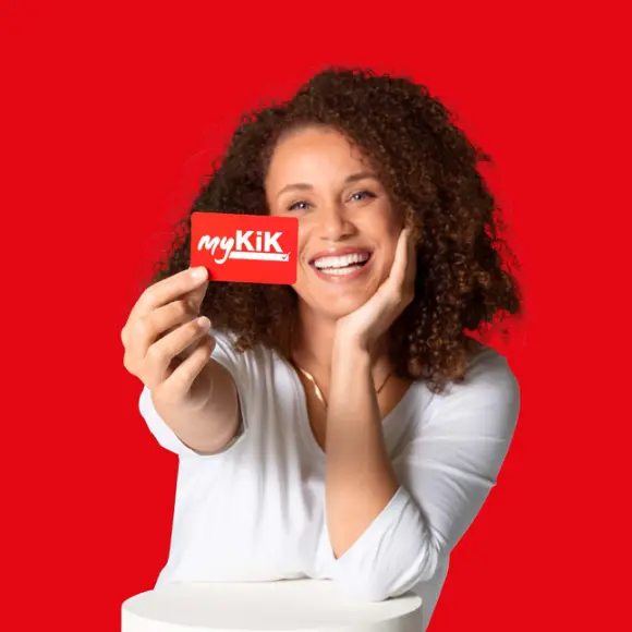 Person mit lockigem Haar hält eine rote myKik Karte vor einem roten Hintergrund