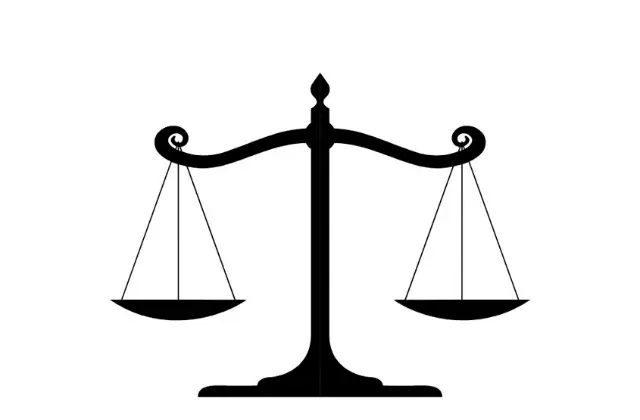 Ein klassisches Gerechtigkeitssymbol: eine ausgewogene Waage in schwarzer Silhouette vor weißem Hintergrund.