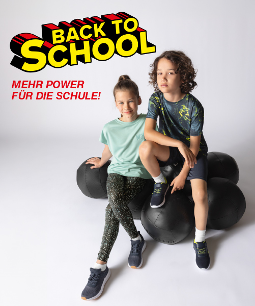 Zwei Kinder sitzen auf großen schwarzen Gymnastikbällen und präsentieren farbenfrohe Sportbekleidung.