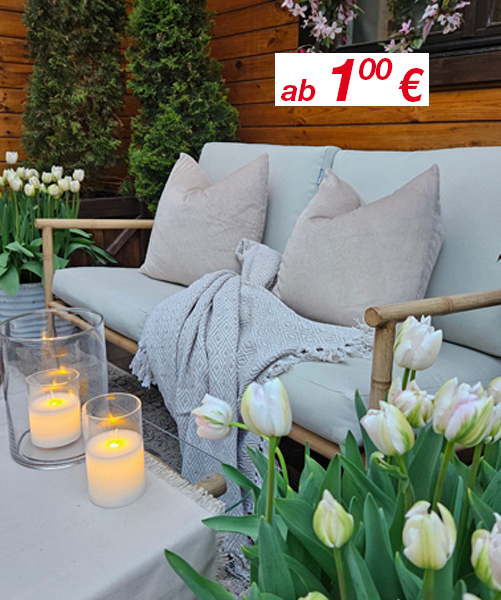 Gemütliche Sitzgelegenheit im Freien mit weichen Kissen, einer Kuscheldecke, Kerzen und blühenden Tulpen – hervorgehoben durch ein Preisschild in der Ecke.